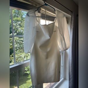 This is a white bodyxon dress with puff sleeves from Vici.